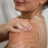 Kropsscrub masseres ind på skulder og overarm i badet.