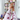 Et par fødder er løftet op foran en bogreol, hvor der er tegnet små smileys med creme på tæerne. Personen har lyserøde Hello Kitty-bukser på og sidder afslappet derhjemme.