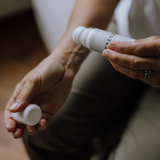 En person påfører “Breeze” roll-on fra Cana Care på håndleddet – en kølende booster med beroligende effekt.